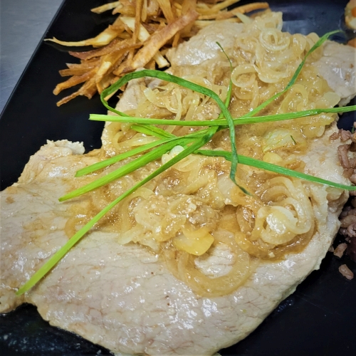 Bistec de cerdo encebollado